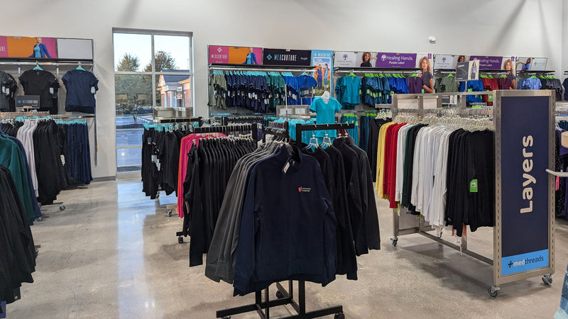 Garfield scrub store shown with Med Couture and Healing Hands scrubs displayed in the background. 